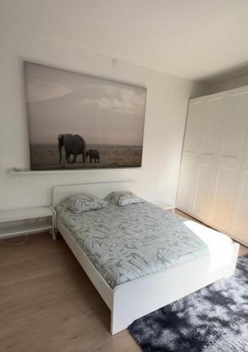 a bedroom with a bed with a painting on the wall at la casa de gege in Mellet