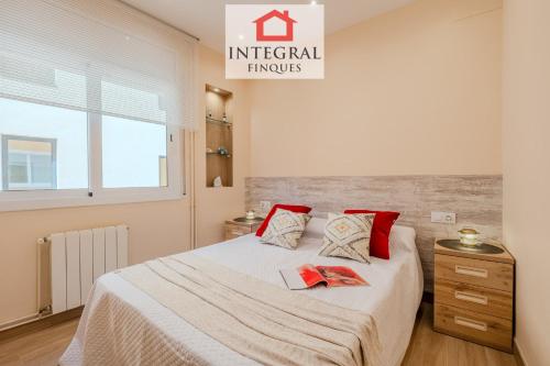 a bedroom with a large bed with red pillows at Casa Terral in Palamós