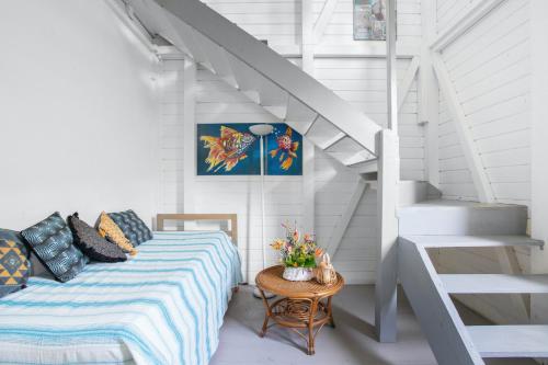 a bedroom with a bed with a table and stairs at Appartement charmant au Carbet avec vue sur la mer - 50 m² in Le Carbet