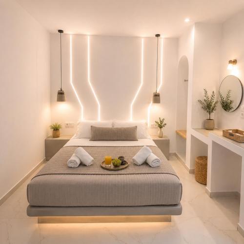 a bedroom with a bed with a tray of fruit on it at Pattys Desing Suites- Private Hot Tub with yard- Fira Center in Firostefani