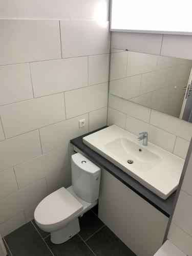 ein weißes Badezimmer mit Toilette und Waschbecken in der Unterkunft Hostel Cologne in Köln
