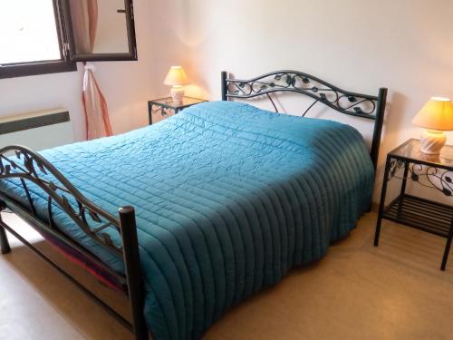 a bedroom with a bed with a blue comforter at Appartement charmant avec vue sur lac et montagne – 75 m² in Fontrabiouse