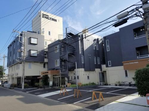 a building with a parking lot in front of it at Tsukuba Daily Inn in Tsukuba