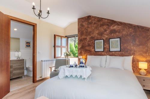 a bedroom with a large bed and a bathroom at La Casona de Omaña in Fasgar
