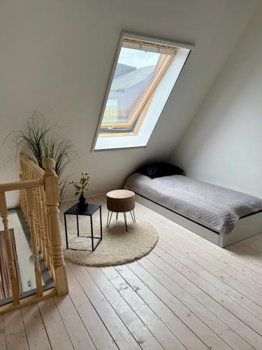 a attic bedroom with a bed and a window at Sunset House Svencele in Svencelė