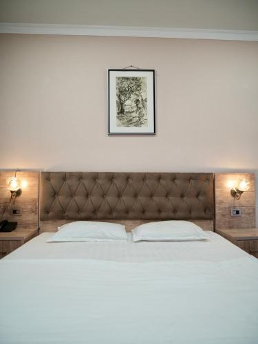 a large bed in a bedroom with two lamps at Dream Inn H&A in Tashkent
