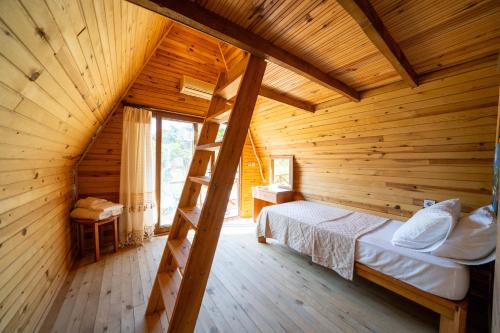 a bedroom with a ladder in a log cabin at Olympos Donkisot Pansiyon in Antalya