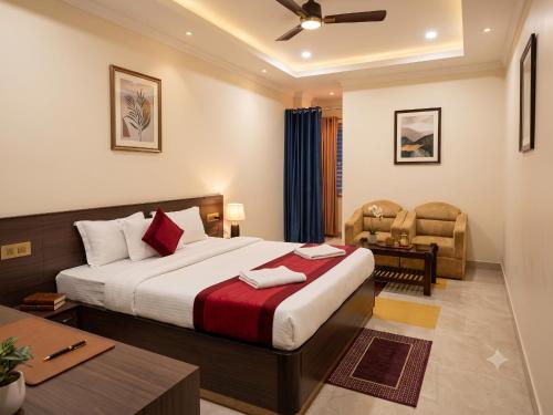 a hotel room with a bed and a chair at Hotel Orion in Bhadrak