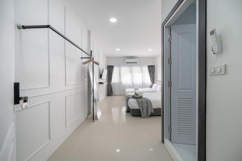 a white room with a door and a bed at Arun Sa Wad - Chinatown House in Bangkok