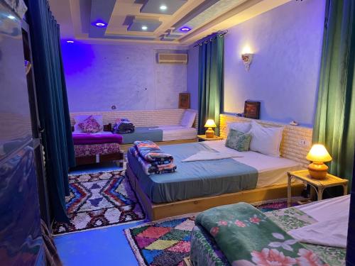 a bedroom with two beds and a couch in a room at Sumptuous Villa in Aït Ben Haddou with Private Pool in Aït Benhaddou