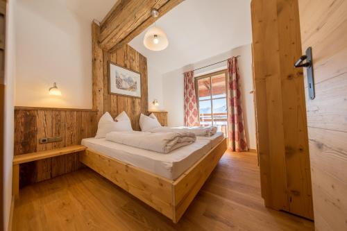 a bedroom with a bed in a room with wooden walls at Ahornlodge in Mayrhofen