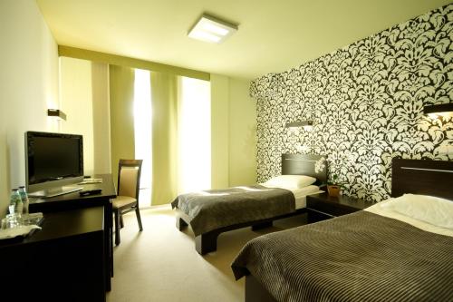 a hotel room with two beds and a television at Hotton Hotel in Gdynia