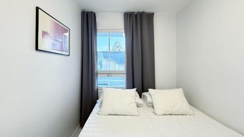 a bedroom with a bed with two pillows and a window at Apartamento la Casa Tahko in Kuopio