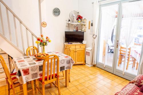 a dining room with a table and chairs and a television at Maison accueillante à Leucate avec jardin et terrasse in Leucate