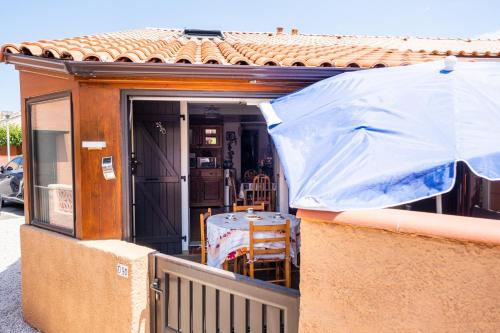 a house with an umbrella on a porch at Maison accueillante à Leucate avec jardin et terrasse in Leucate