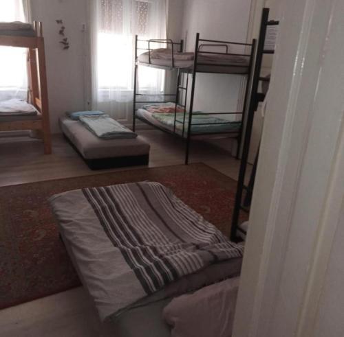 a room with three bunk beds and a rug at Station Backpackers in Budapest