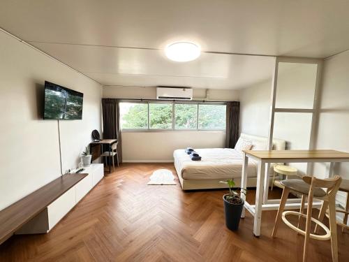 a bedroom with a bed and a desk and a table at Lykke Room Poppular Condo P1 in Ban Bang Phang