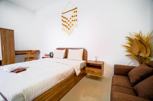 a bedroom with a bed and a couch at Timeless Sevilla Luxe in Ngemplak