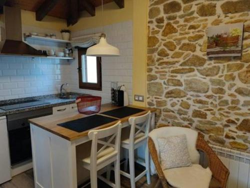 a kitchen with a stone wall and a table and chairs at Charming house in Biescas with shared pool in Biescas