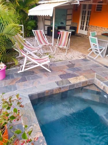 a patio with two chairs and a swimming pool at Appartement charmant à Sainte-Luce avec vue sur la montagne in Sainte-Luce