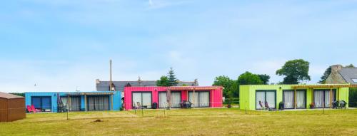 a row of colorful houses in a field at Maison cosy à La Bouillie + jardin in La Bouillie