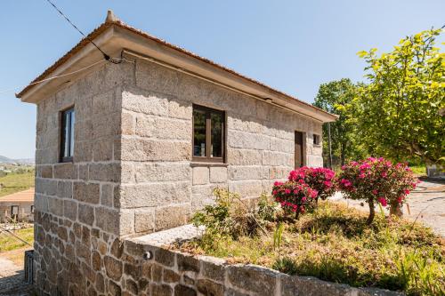 a stone house with pink flowers in front of it at Idyllic Villa in Fornos + Pool! in Fornos