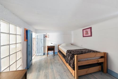 a bedroom with a bed and a desk and a window at Appartement cocooning à Barrême, 30 m² avec balcon in Barrême