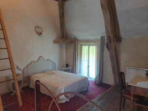 a bedroom with a bed and a table and a window at Charming room in Sornay