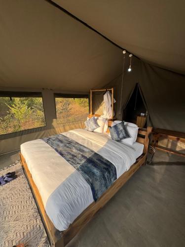 a bedroom with a large bed in a tent at Mara Hilltop in Sekenani