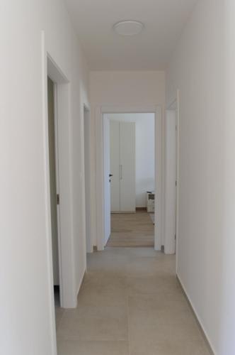 an empty hallway with white walls and a white floor at Villa GB in Brtonigla