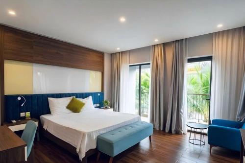 a bedroom with a large bed and a blue couch at Nova Villas Phu Quoc in Phú Quốc