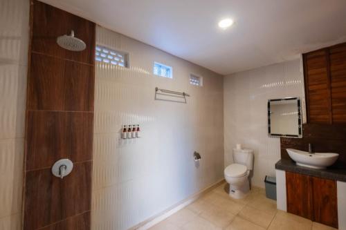 a bathroom with a toilet and a sink at Druwa Bali in Uluwatu
