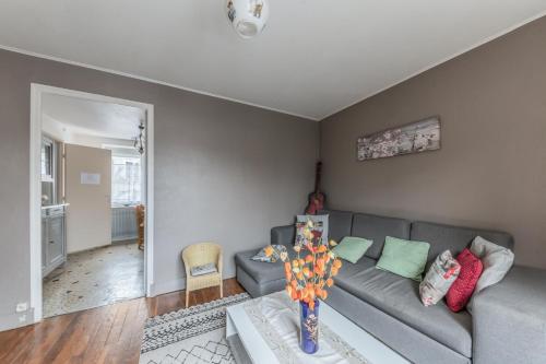 a living room with a gray couch and a table at Maison conviviale à Bourbon-Lancy avec équipements modernes in Bourbon-Lancy