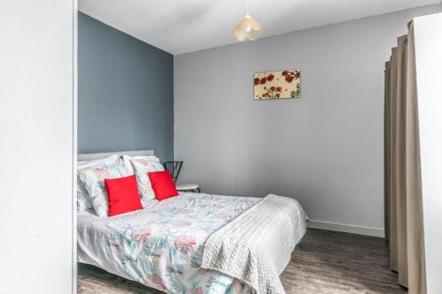 a bedroom with a bed with red pillows at Maison conviviale à Bourbon-Lancy avec équipements modernes in Bourbon-Lancy