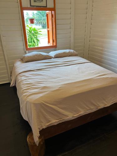 a large bed in a room with a window at The Nest in Cherating