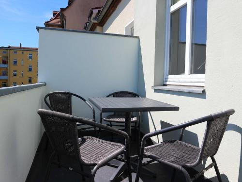 two chairs and a table on a balcony at Ferienwohnung MIWE Gesundheitszent in Forst