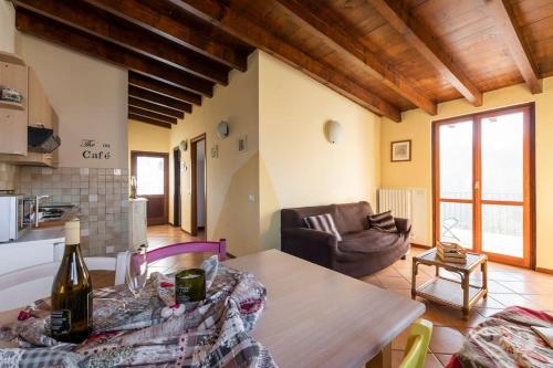 a kitchen and living room with a table and a couch at Charming House in Vesime with Shared Pool in Vesime