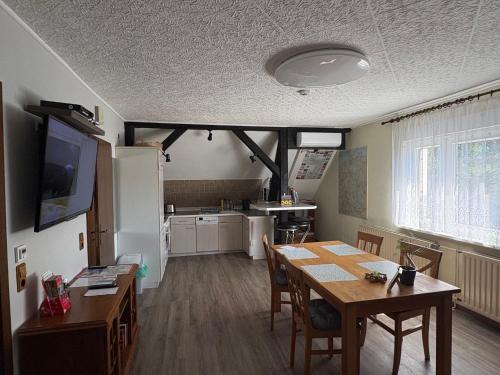 a kitchen and dining room with a table and a refrigerator at Ferienwohnung Nordstadt in Forst
