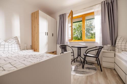 a bedroom with a bed and a table and chairs at Ferienwohnung Leibnitz Südsteiermark in Leibnitz