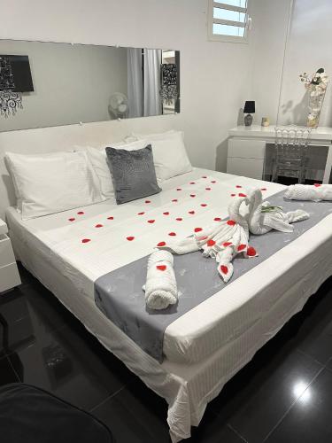 a large white bed with stuffed animals on it at Appartement charmant à Sainte-Rose, 60m² + piscine in Sainte-Rose