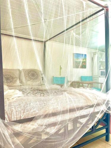 a bedroom with a bed covered in mosquito net at Appartement moderne à Le Lamentin avec piscine partagée - 20m² in Le Lamentin