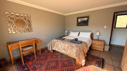 a bedroom with a bed and a table and a mirror at Riverbend on Komati in Machadodorp