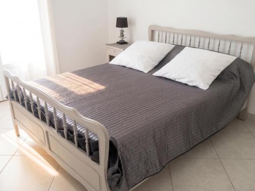 a bedroom with a bed with a gray comforter at Maison confortable avec vue sur la mer et la montagne à Oletta. in Oletta