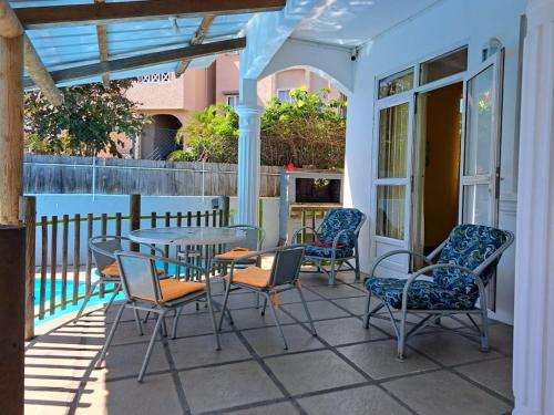 a patio with a table and chairs on a porch at Spacious Apartment in Pamplemousses with Private Pool in Pamplemousses Village