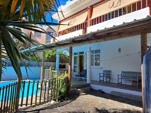 a house with a porch and a swimming pool at Spacious Apartment in Pamplemousses with Private Pool in Pamplemousses Village