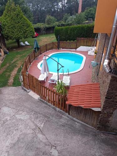 a swimming pool with chairs and an umbrella at Spacious villa with pool in Empalme de Vilar - 300 m², 8 guests in Vilar