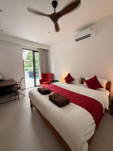 a bedroom with a large bed with a ceiling fan at Villa Manu in Ko Phangan