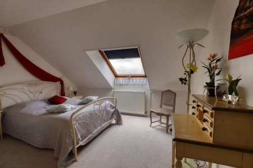 a bedroom with a bed and a desk and a window at Maison spacieuse avec jardin près de Le Bouffay in Commes