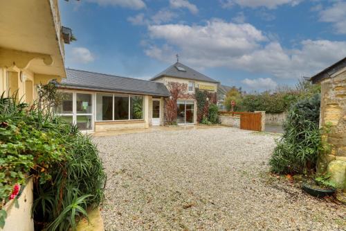 a house with a gravel driveway in front of it at Maison spacieuse avec jardin près de Le Bouffay in Commes