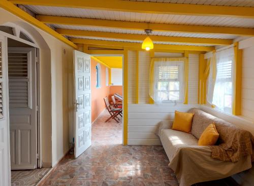 a living room with a couch and a window at Maison charmante à Le Diamant avec vue sur mer et jardin in Le Diamant